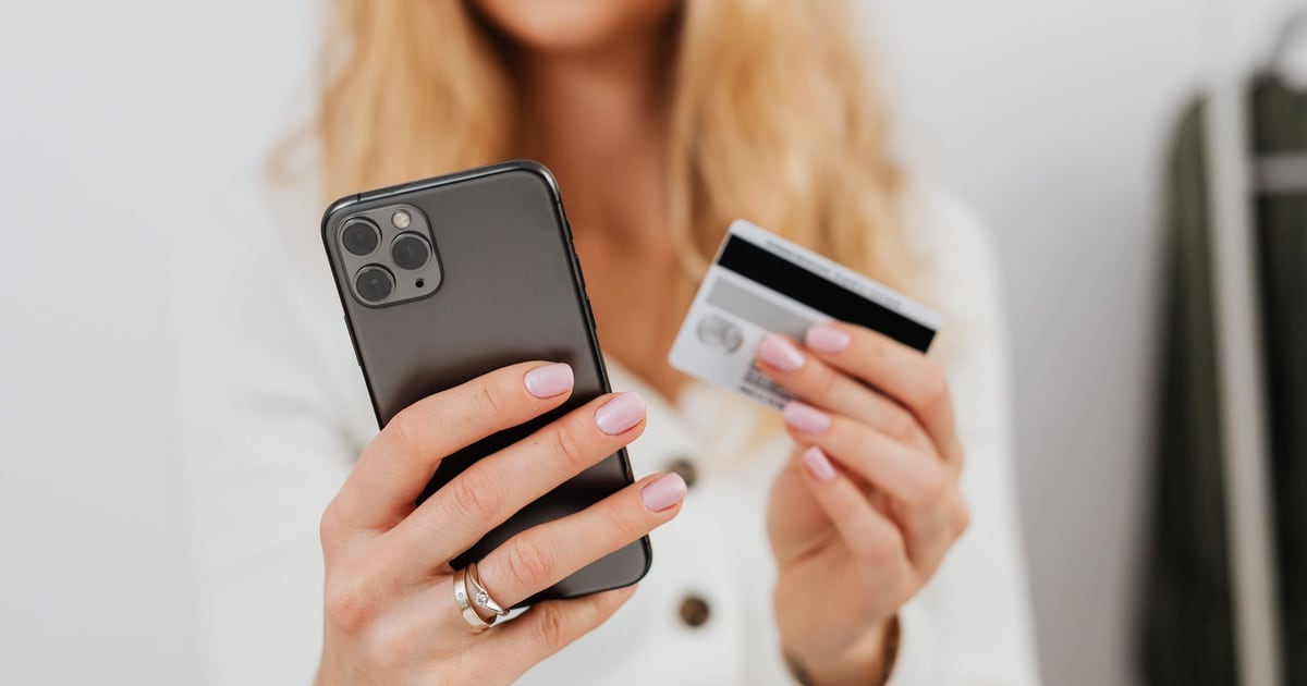 Девушка с iPhone и банковской картой в руках