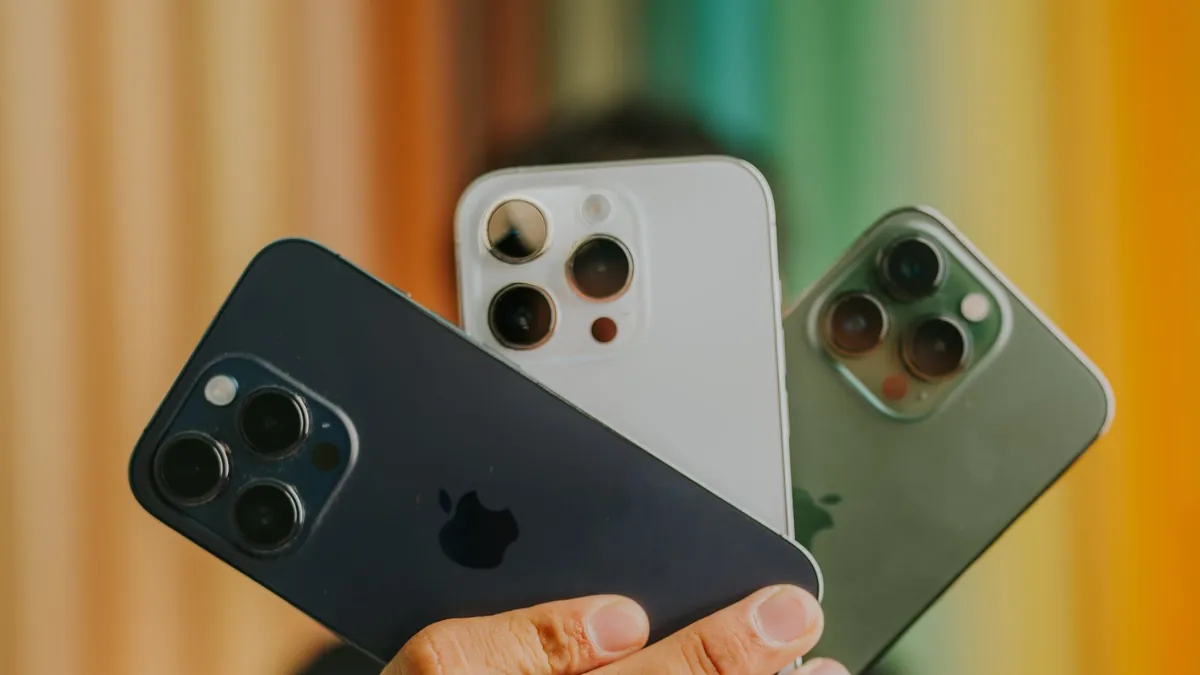 Три iPhone Pro разных цветов в руке